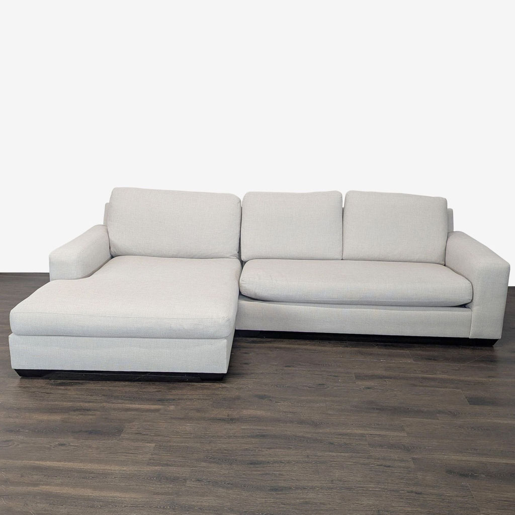Light gray Pottery Barn sectional with left-facing chaise, plush cushions, and modern design on wood flooring.