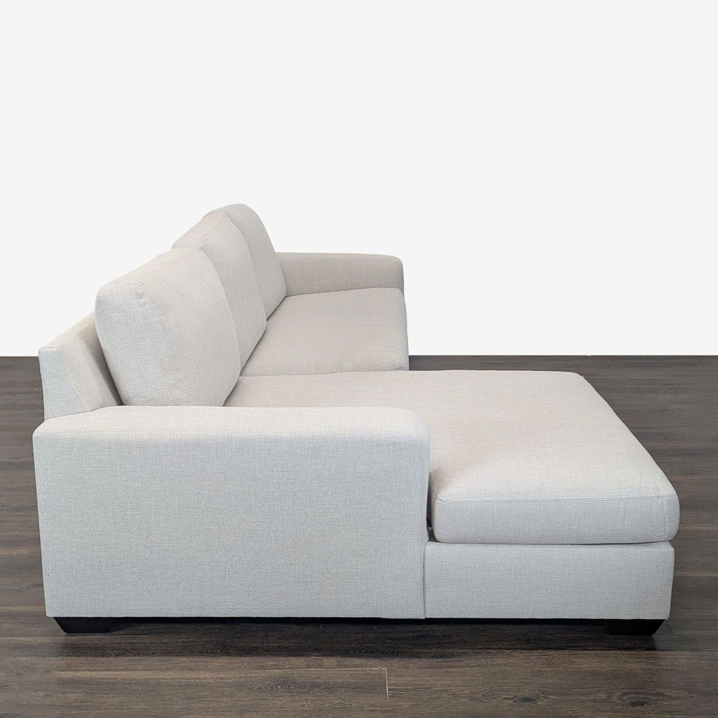Side view of a Pottery Barn sectional in neutral gray fabric, highlighting the left-facing chaise and clean lines.