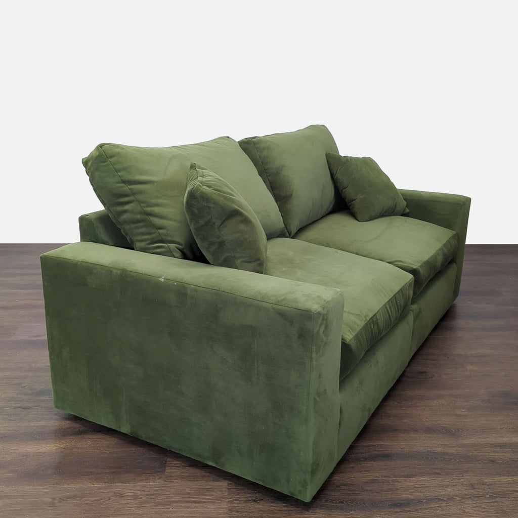 Modern green loveseat featuring faux suede, included throw pillows, and a comfortable, firm seat.