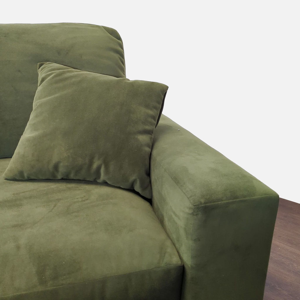 Cozy green loveseat with sleek lines, plush faux suede fabric, and two coordinating pillows.