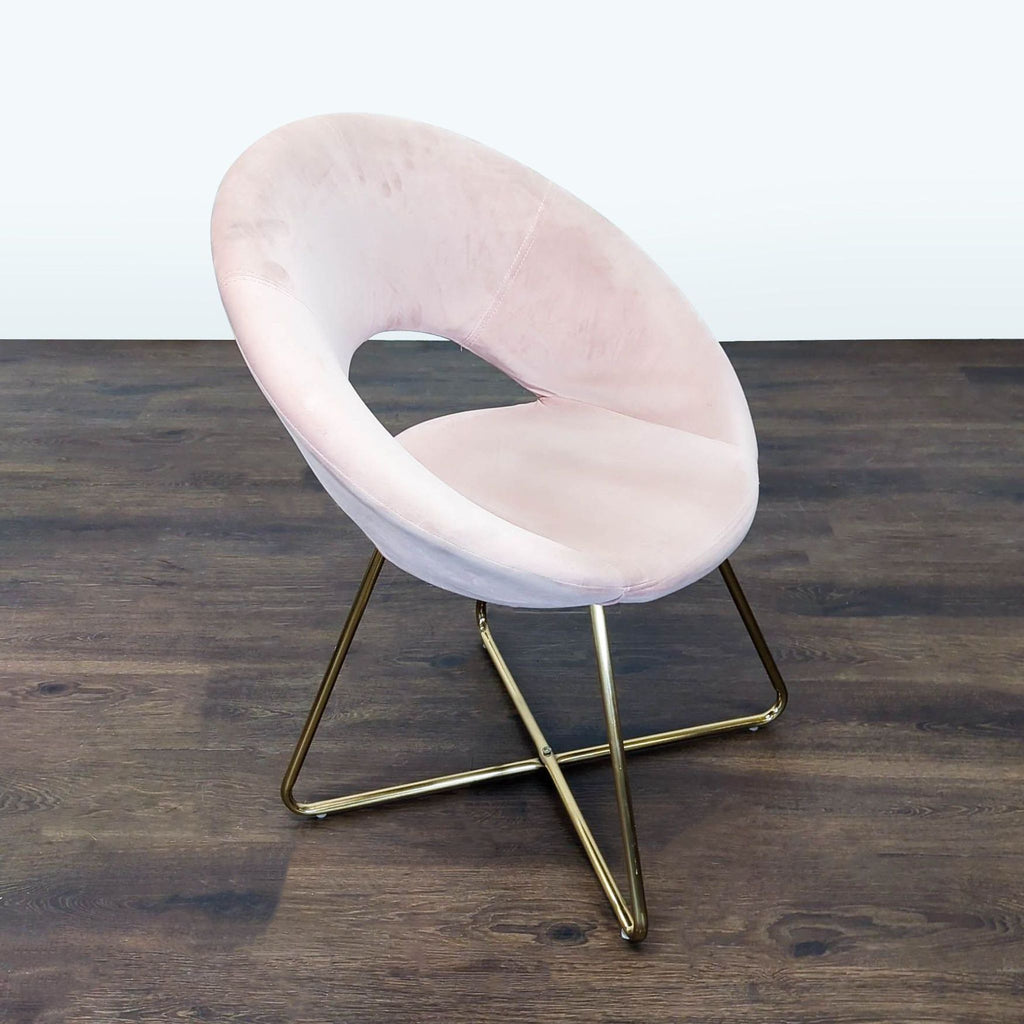 2. Side view of a modern lounge chair, featuring soft pink velvet and gold metal legs, perfect for home décor.