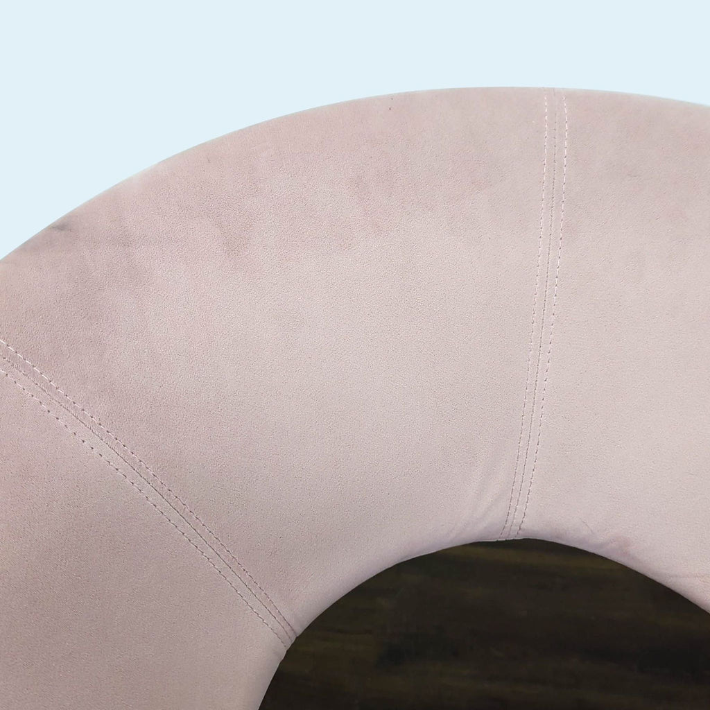 3. Close-up of pink velvet upholstery and stitching on a contemporary lounge chair backrest.