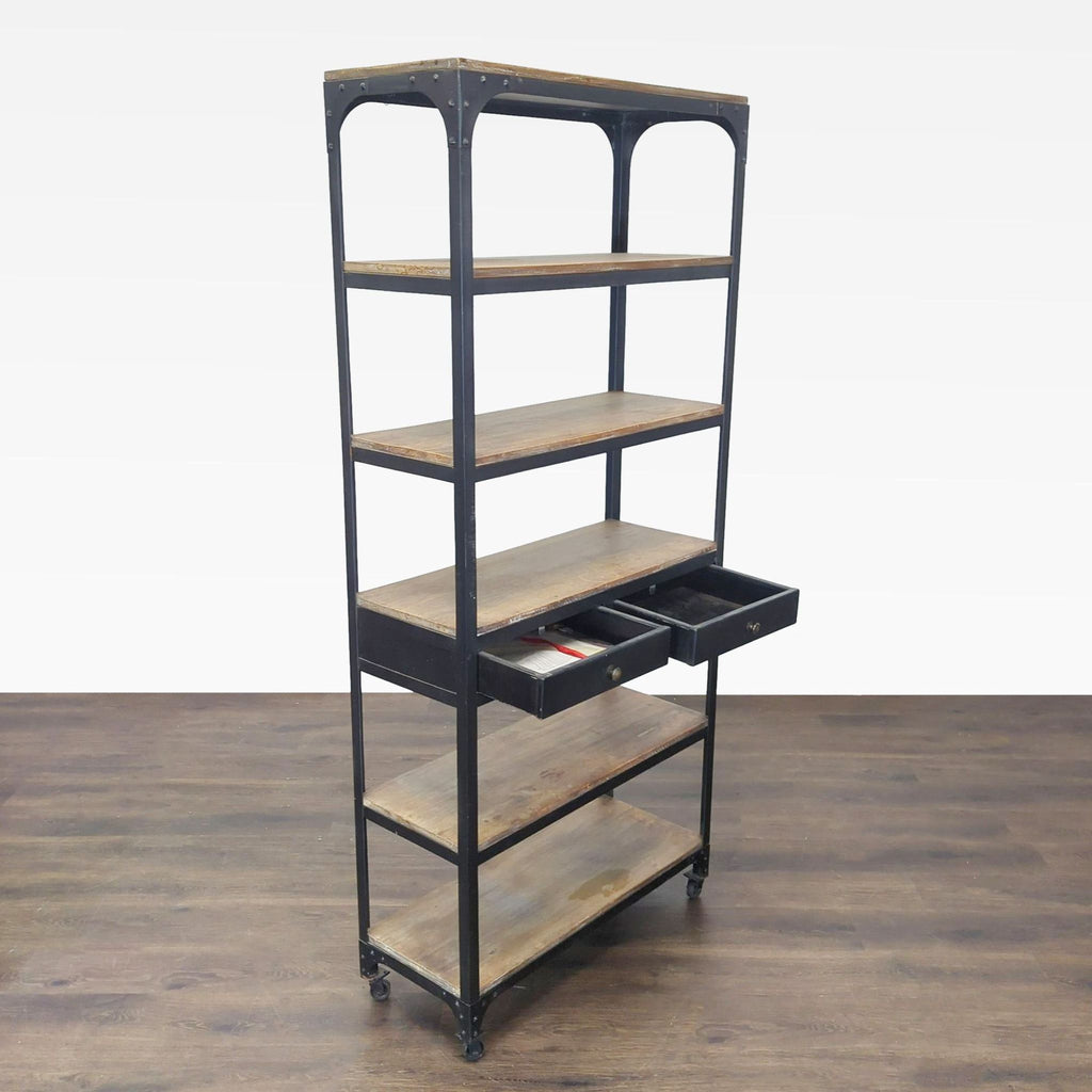 Modern industrial bookshelf by Anthropologie featuring metal frame, wooden shelves, drawers, and wheels for mobility.  