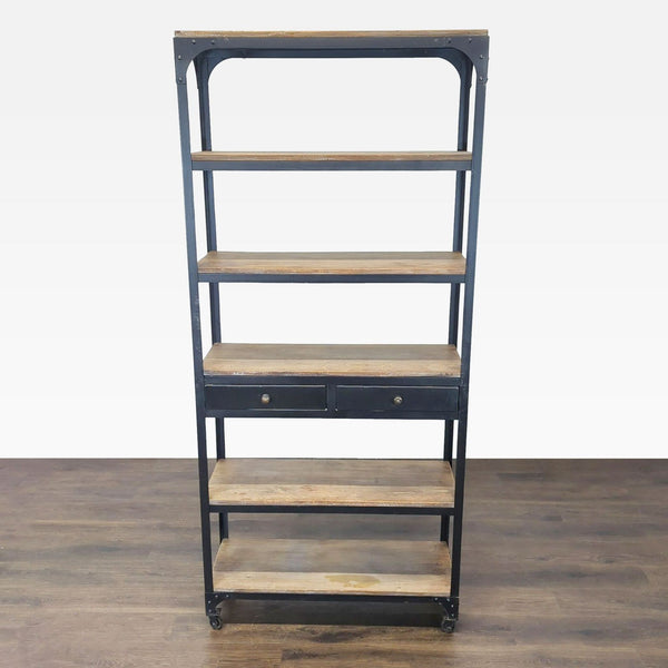 Anthropologie bookshelf with five wood shelves, two drawers, and lockable wheels in a modern industrial style.  