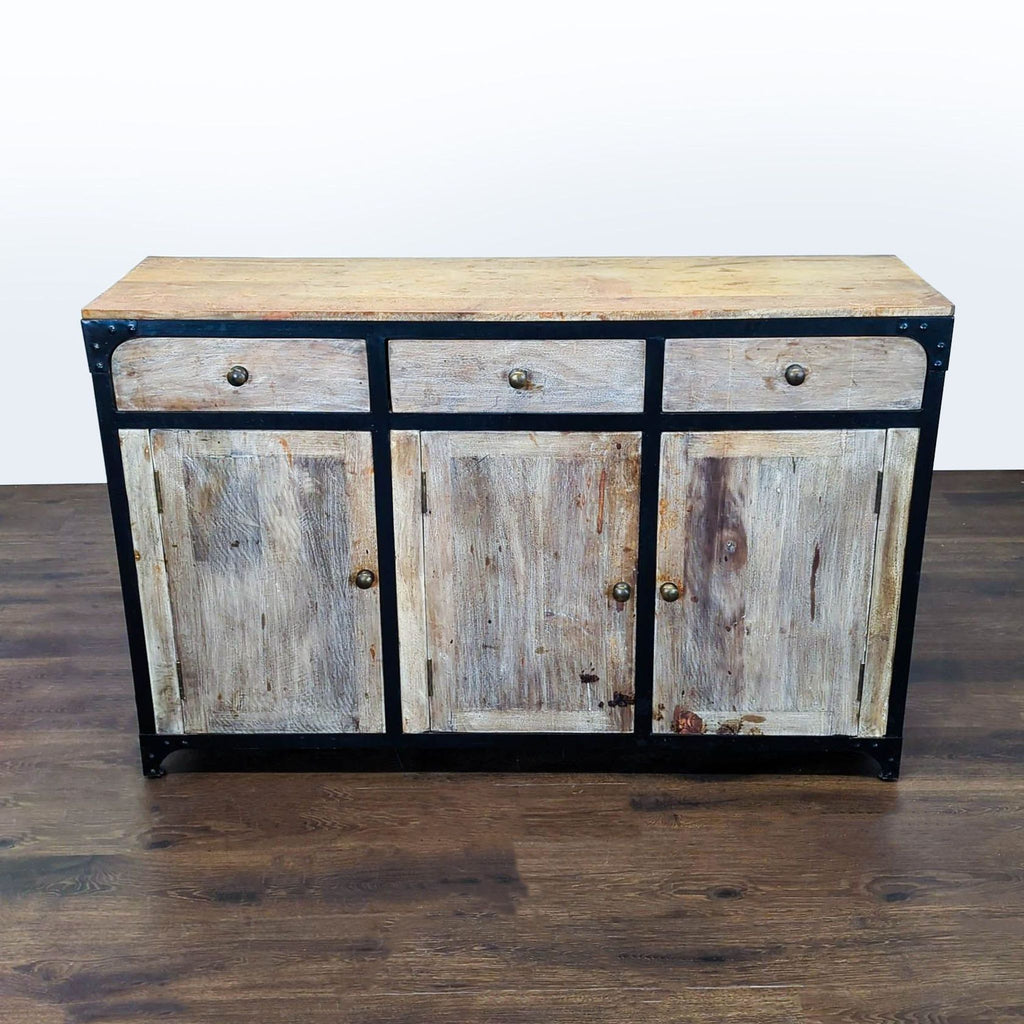 Distressed-finish sideboard with three doors, three drawers, and interior shelves from Anthropologie.