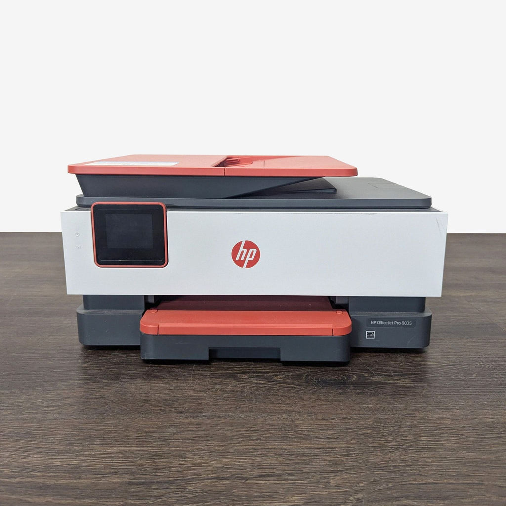 HP OfficeJet Pro 8035 wireless printer in red and gray, featuring touchscreen and compact design.
