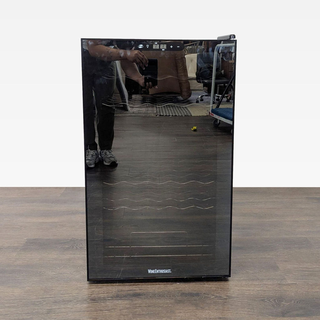 Wine Enthusiast black wine fridge with a glass door and digital controls, perfect for compact wine storage.