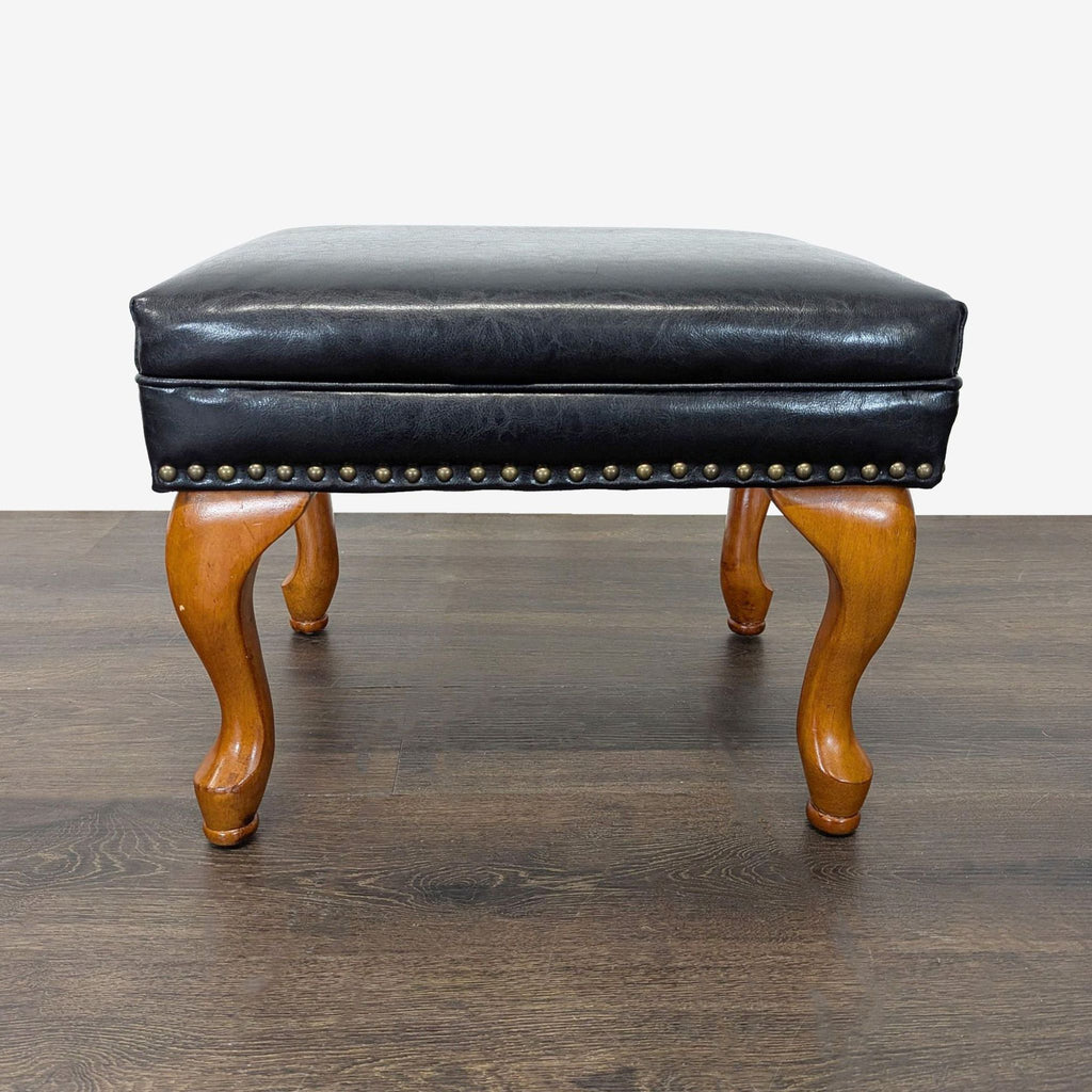 Elegant black leather lounge chair and ottoman set featuring tufted back and sturdy wood legs, ideal for relaxing.