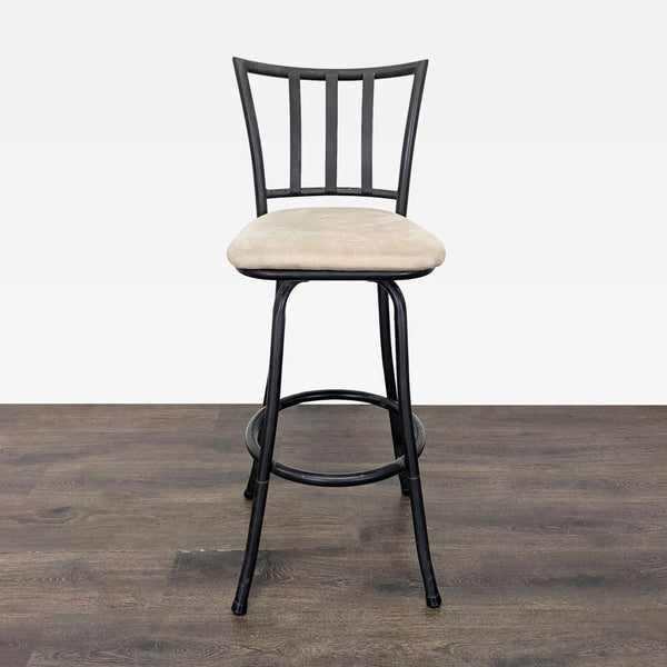 Metal bar stool with beige cushioned seat, black frame, backrest, and footrest for kitchen or bar use.