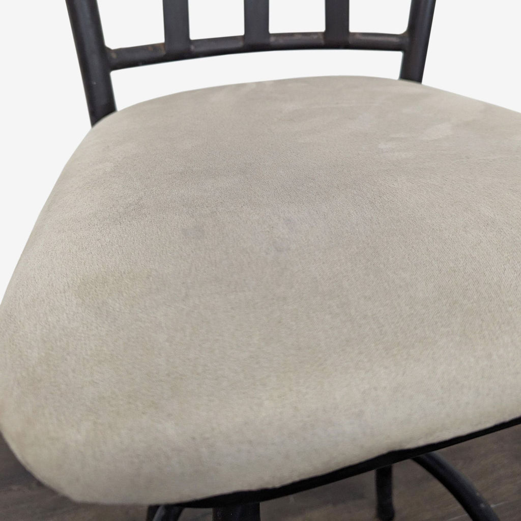 Modern chair categorized as a bar stool with a beige cushion, black metal frame, and comfortable backrest.