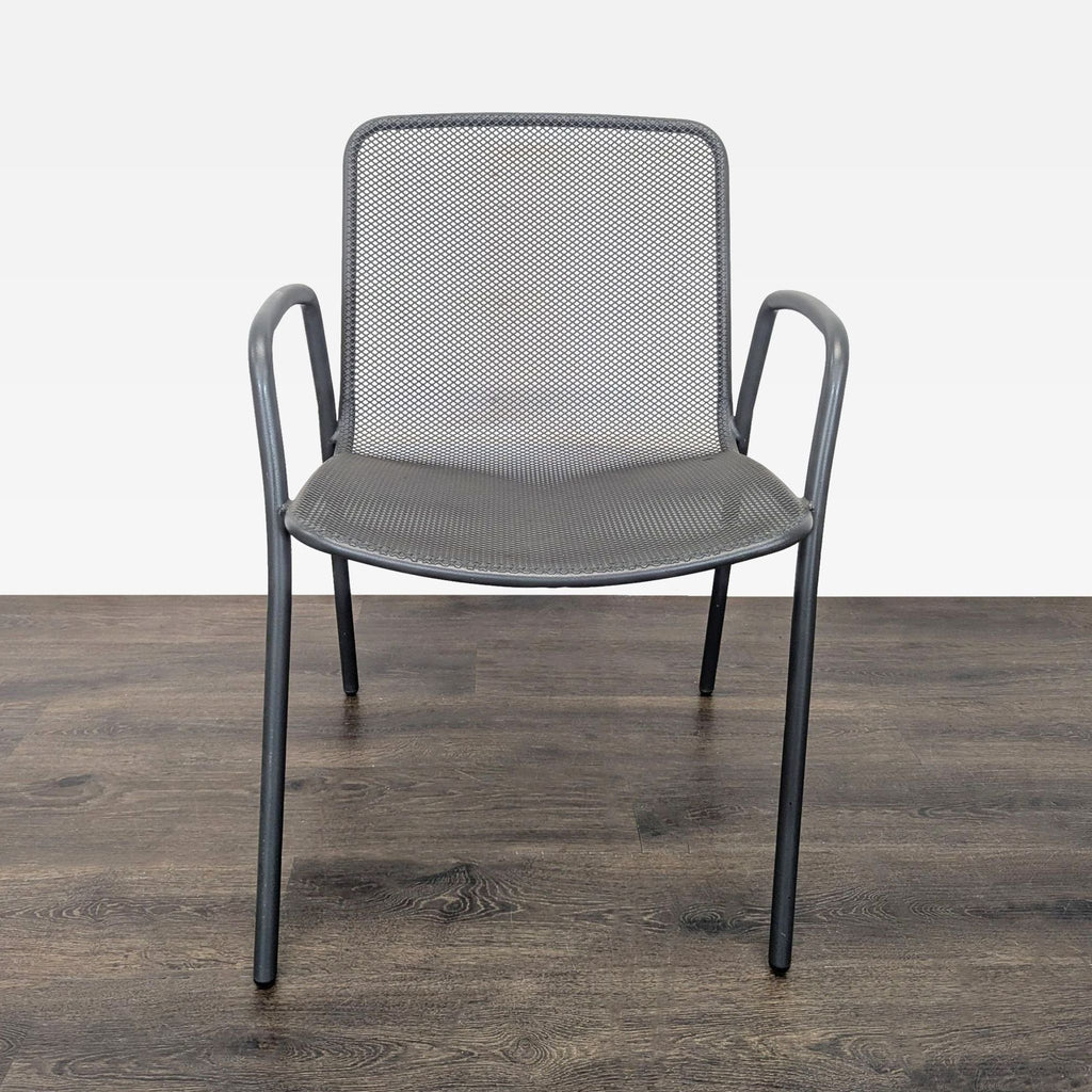 Four modern mesh chairs by Room & Board, featuring armrests and lightweight metal frames for versatile use.