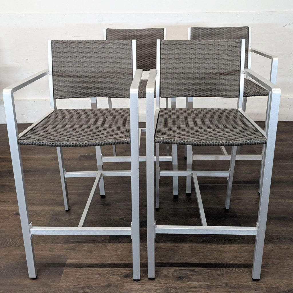 Set of four Christopher Knight Home bar stools with metal frames, wicker seats, and armrests, suitable for patios or bars.