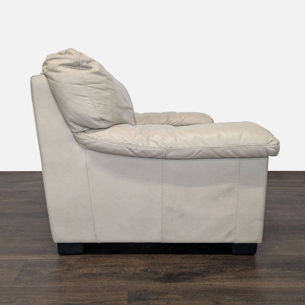 2. Side angle of an Italsofa lounge armchair in soft beige leather, showing thick armrest and modern profile.