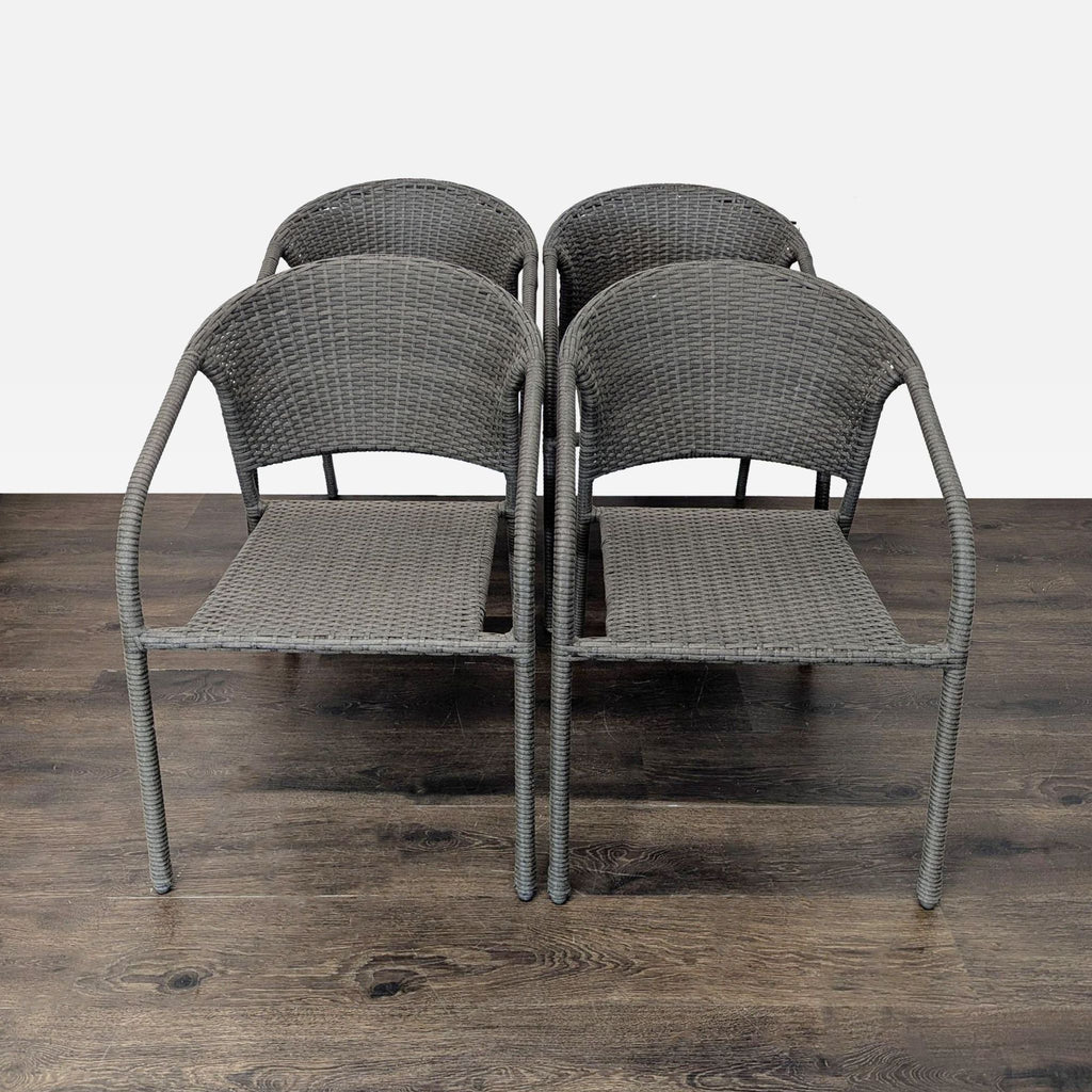 Set of four matching woven patio chairs, stackable and lightweight, shown arranged on a wood floor.