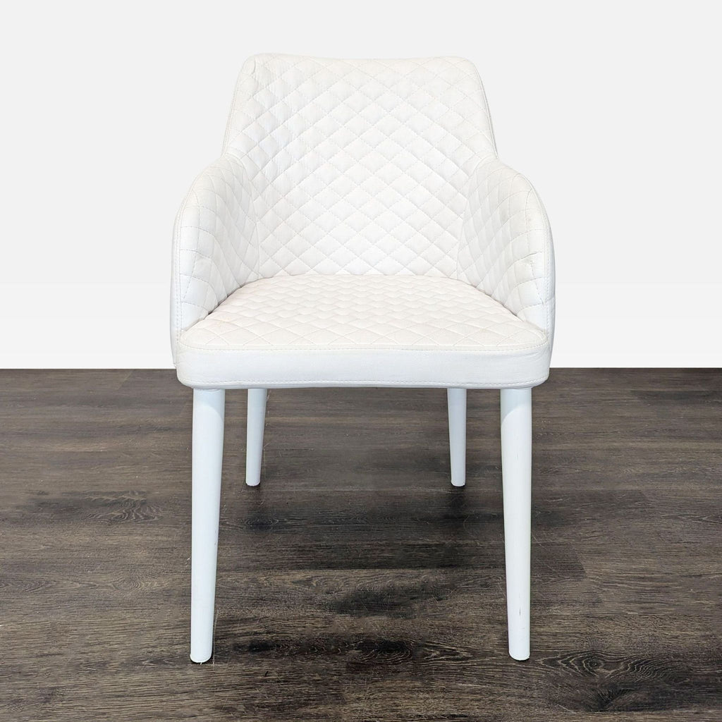 3. Front view of a white quilted Moe's Home Collection dining chair on a dark wooden floor.