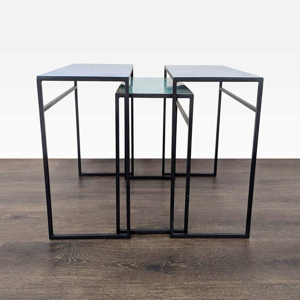 1. Set of three modern CB2 nesting side tables with black metal frames and glass tops, arranged together.
