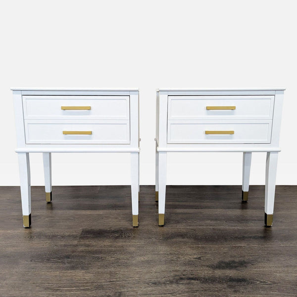 1. Pair of modern white end tables with two drawers, gold handles, and gold-tipped legs on wood floor.