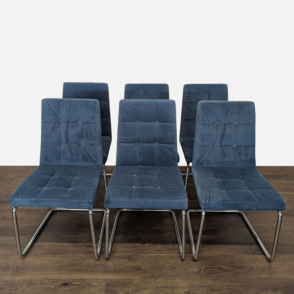 Modern dining chair by CB2 with button-tufted upholstery and sleek metal cantilevered base.