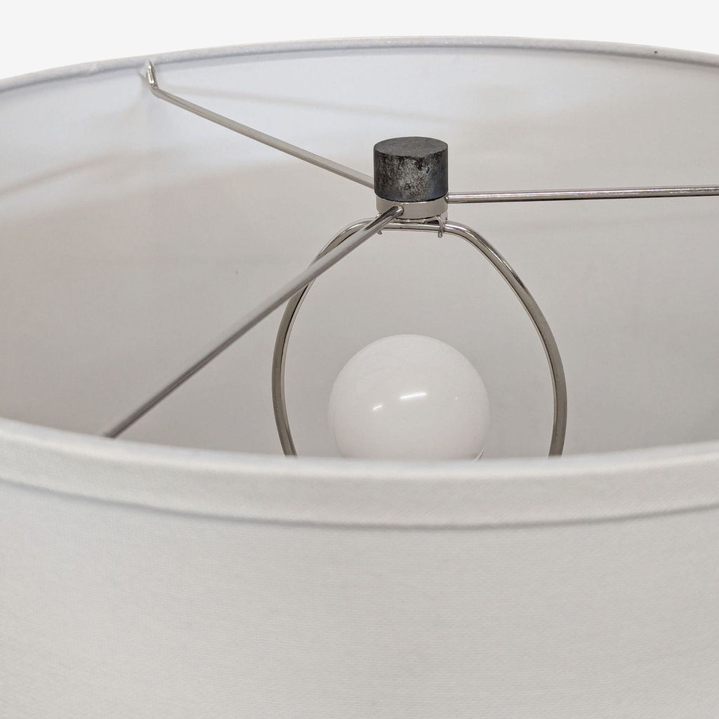 Interior view of the Troy Lighting table lamp’s white fabric shade, showing the metal frame and light bulb.
