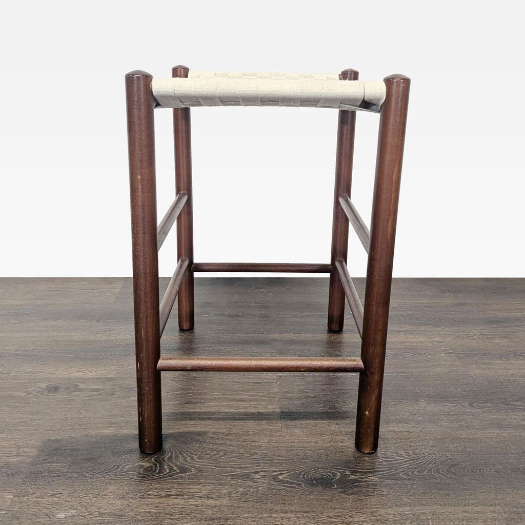 2. Simple backless stool with dark round wood legs and a woven cream seat, shown from the front.