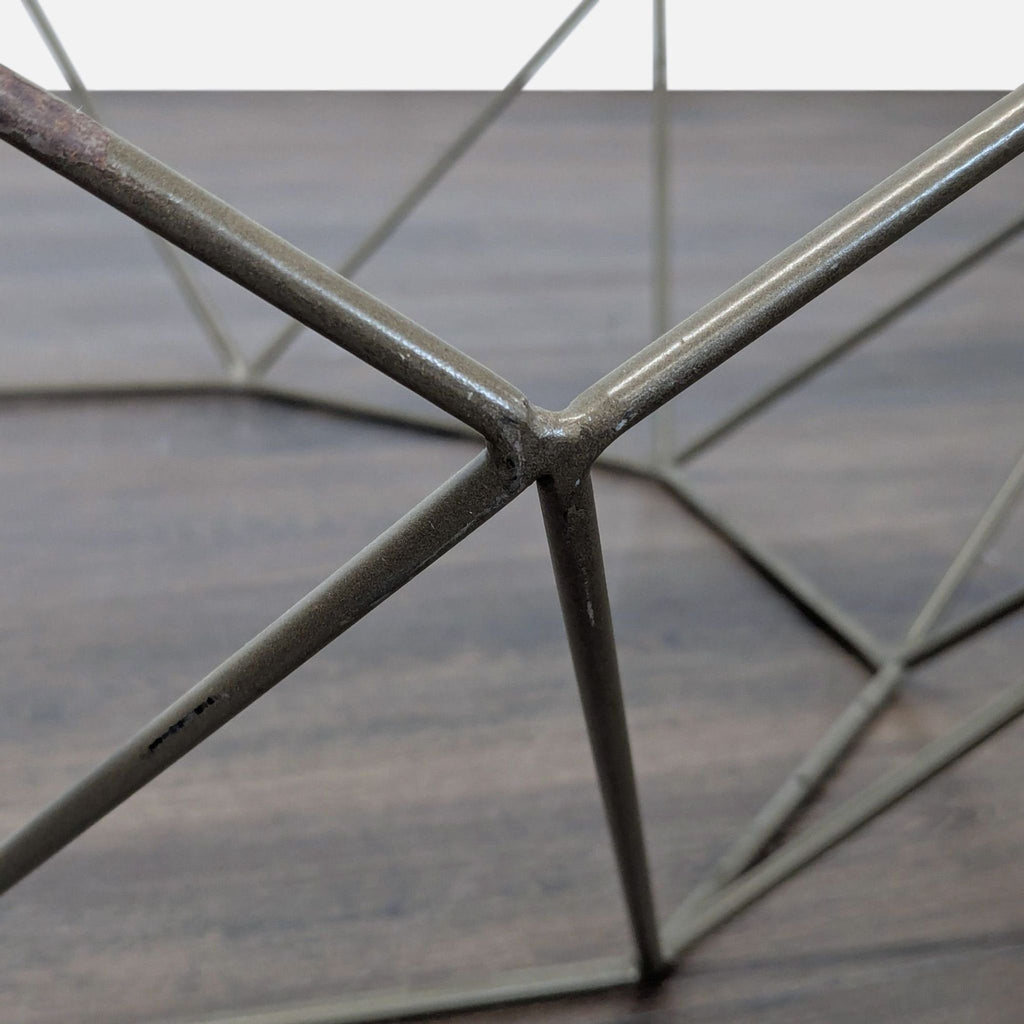 Close-up of the coffee table's metal frame, showing the angular welded wire structure in detail.