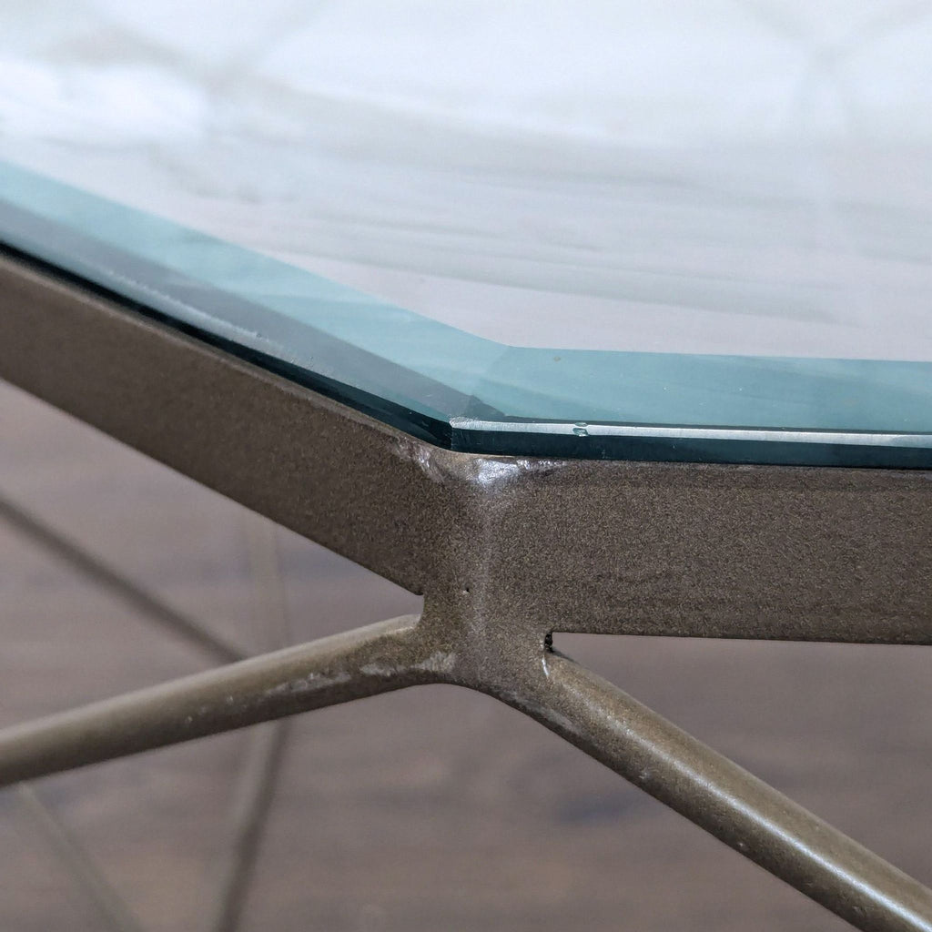 Detail of the glass tabletop edge sitting on the metal frame of the geometric coffee table.