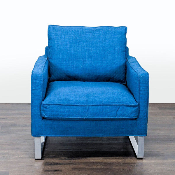 Modern blue Ikea lounge chair with cushion seat, sleek metal legs, and slight arm wear, great for relaxing.  