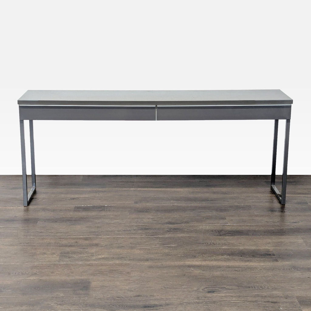 Gray Ikea desk with metal frame and two drawers, ideal for modern offices or studies.