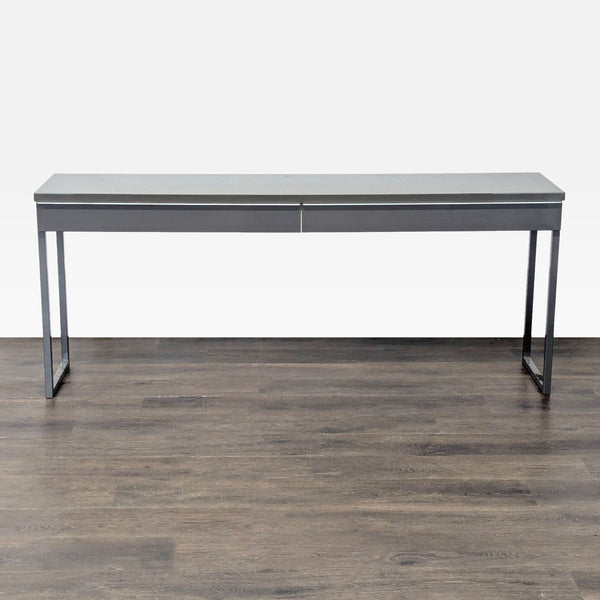 Gray Ikea desk with metal frame and two drawers, ideal for modern offices or studies.