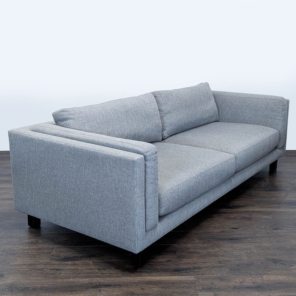 Modern gray Room and Board sofa with boxy design, seats three comfortably on plush cushions.