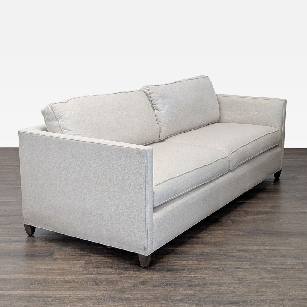 Modern cream 3-seat sofa by Crate & Barrel, featuring soft upholstery, straight arms, and sturdy wood legs.  