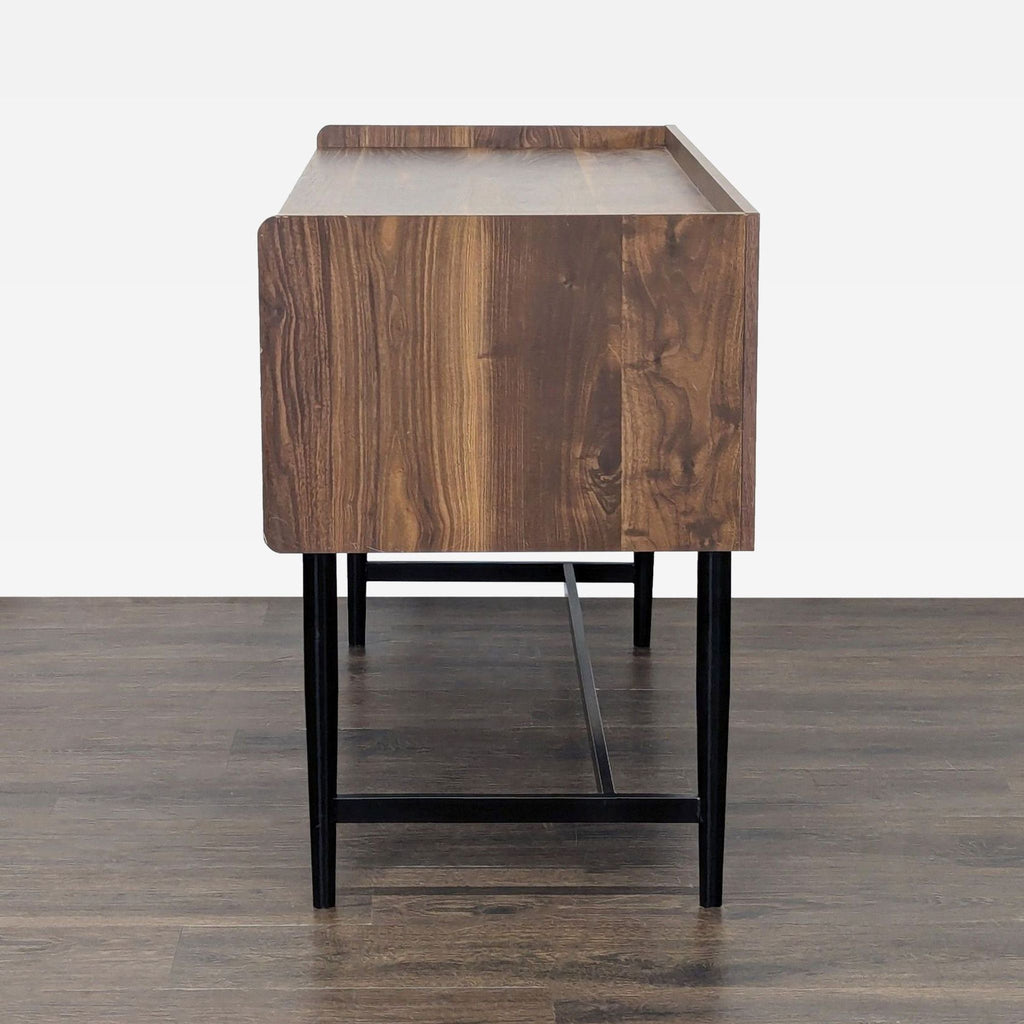Side view of the Sauder desk in wood and black, highlighting the sleek metal legs and smooth cabinet surfaces.