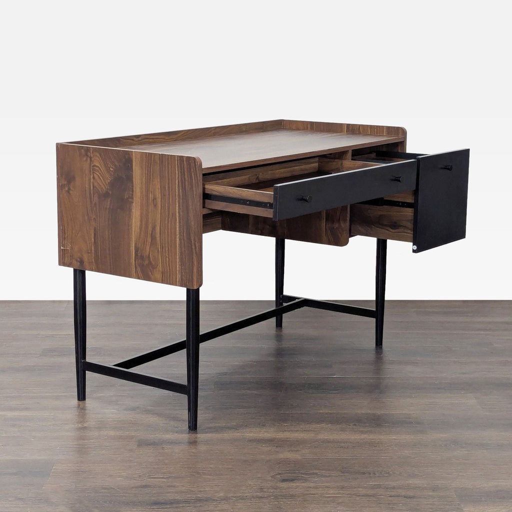 Angled view of a Sauder desk featuring a warm wood finish, open storage drawer, and modern black accents.  