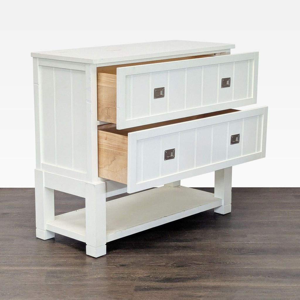 1. White wooden cabinet with two large drawers open and a lower shelf, shown on a dark floor.