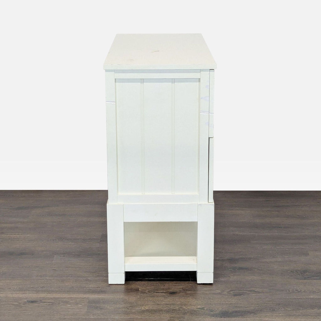 2. Side view of a white wooden cabinet with a paneled finish, emphasizing its rectangular structure.