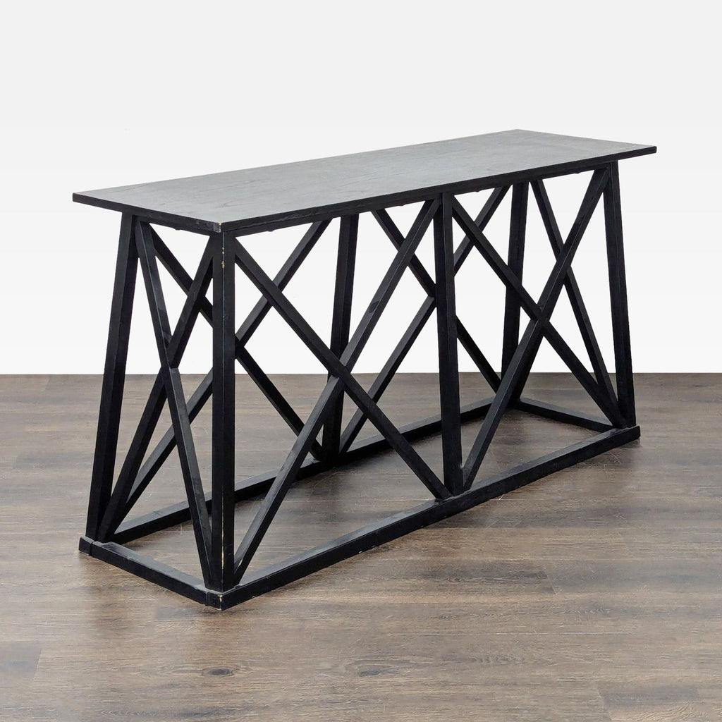 1. Black console table from Target with a geometric, crisscross base design on wood flooring.