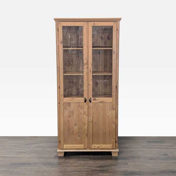 1. Tall wooden cabinet with glass-paneled double doors, shown closed on a wood floor, in the Cabinet category.