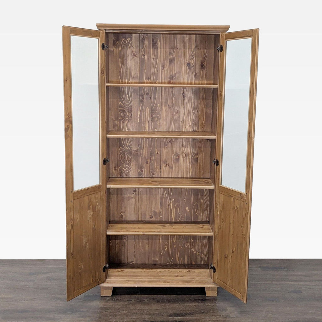 2. Cabinet made of natural wood, doors open to reveal spacious shelving for storage or display, on wood flooring.