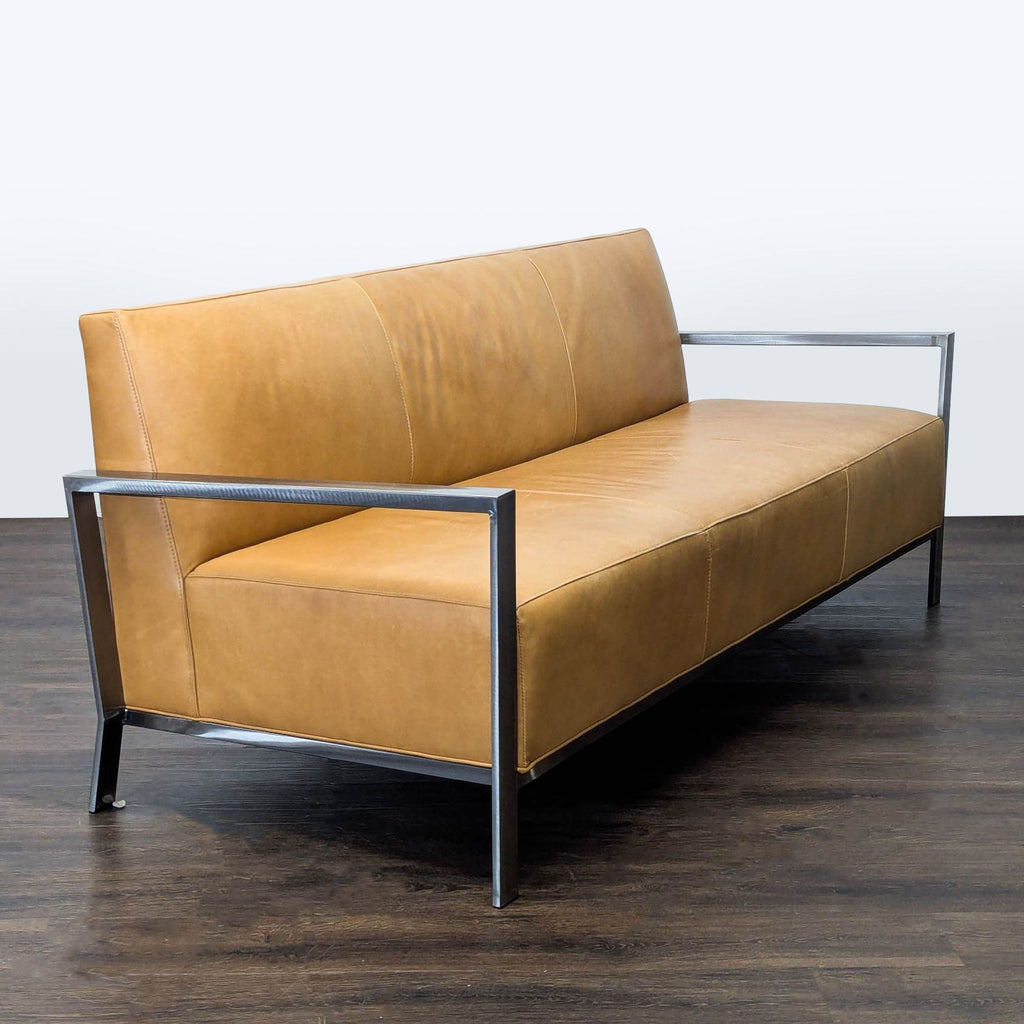 2. Modern 3-seat tan leather sofa by Room & Board, angled view showing sleek metal armrests.