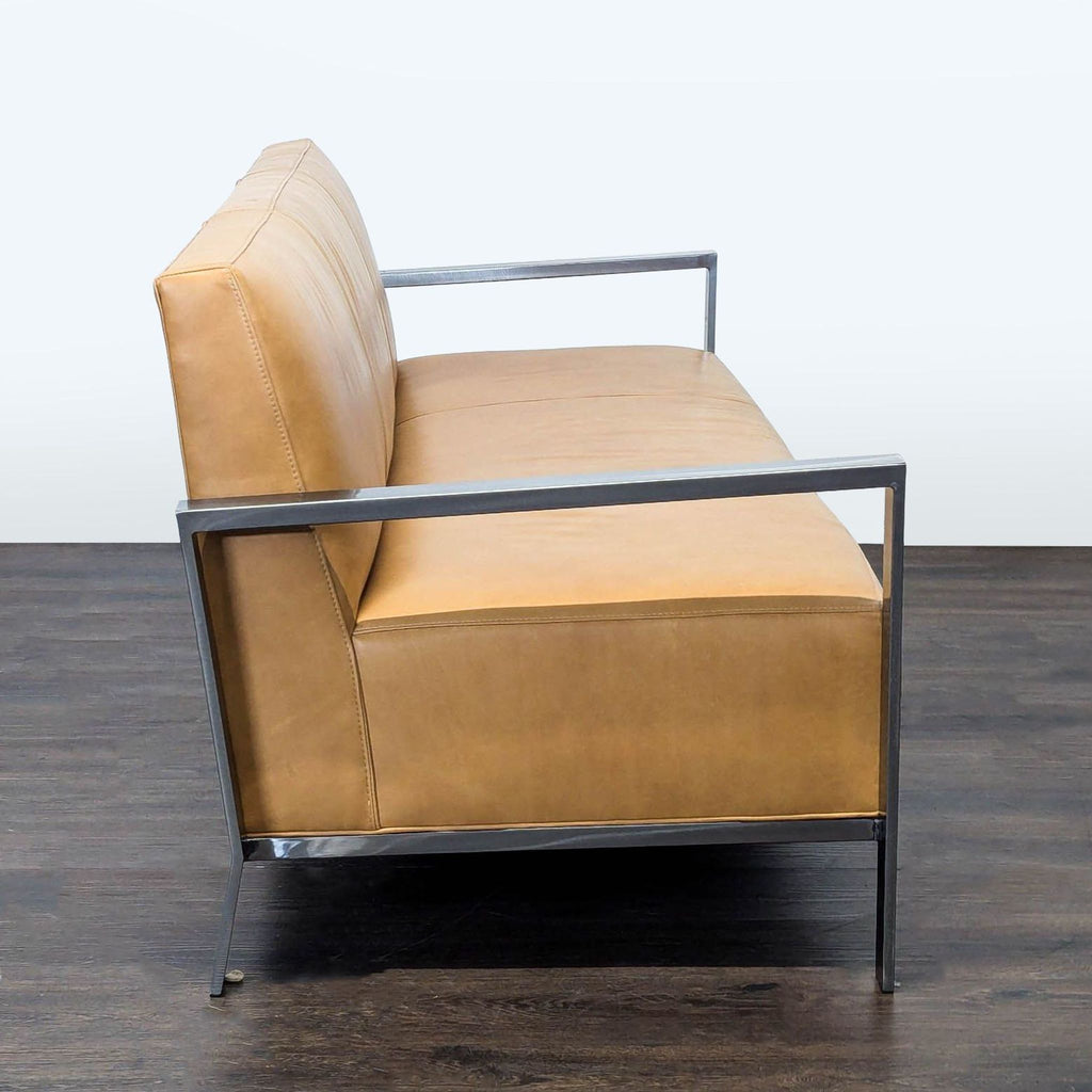 3. Side view of a Room & Board 3-seat sofa featuring tan leather cushions and a minimalist metal frame.