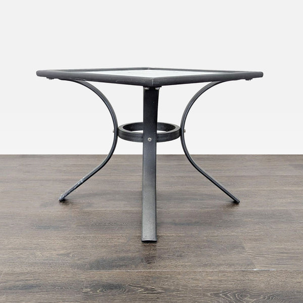 1. Square table with black metal frame and curved legs, suitable for indoor or outdoor use in the tables category.  
