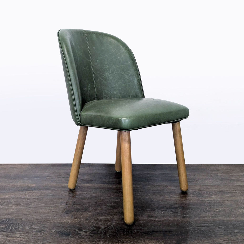 Angled view of green upholstered dining chair with wooden legs, ideal for modern dining spaces.
