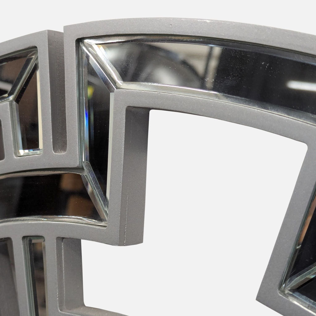 Decorative mirror framed by a geometric wood design, accented with glass pieces along the edge.