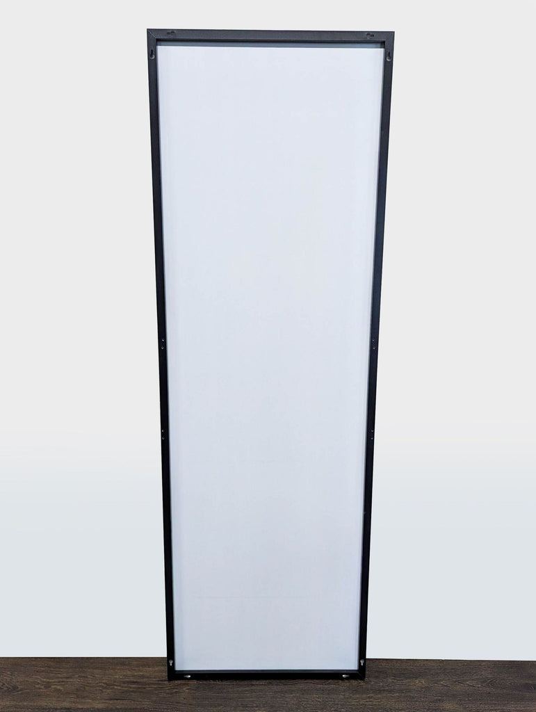 1. Full-length rectangular mirror with a black frame, standing on a dark wooden floor against a white wall.