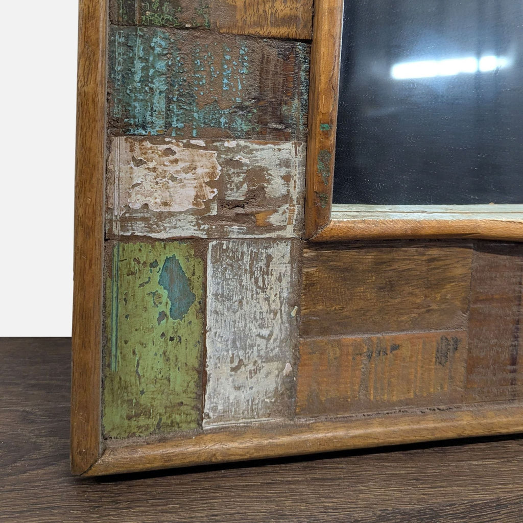 2. Corner detail of a vintage mirror frame featuring chipped paint in earth tones and natural wood textures.