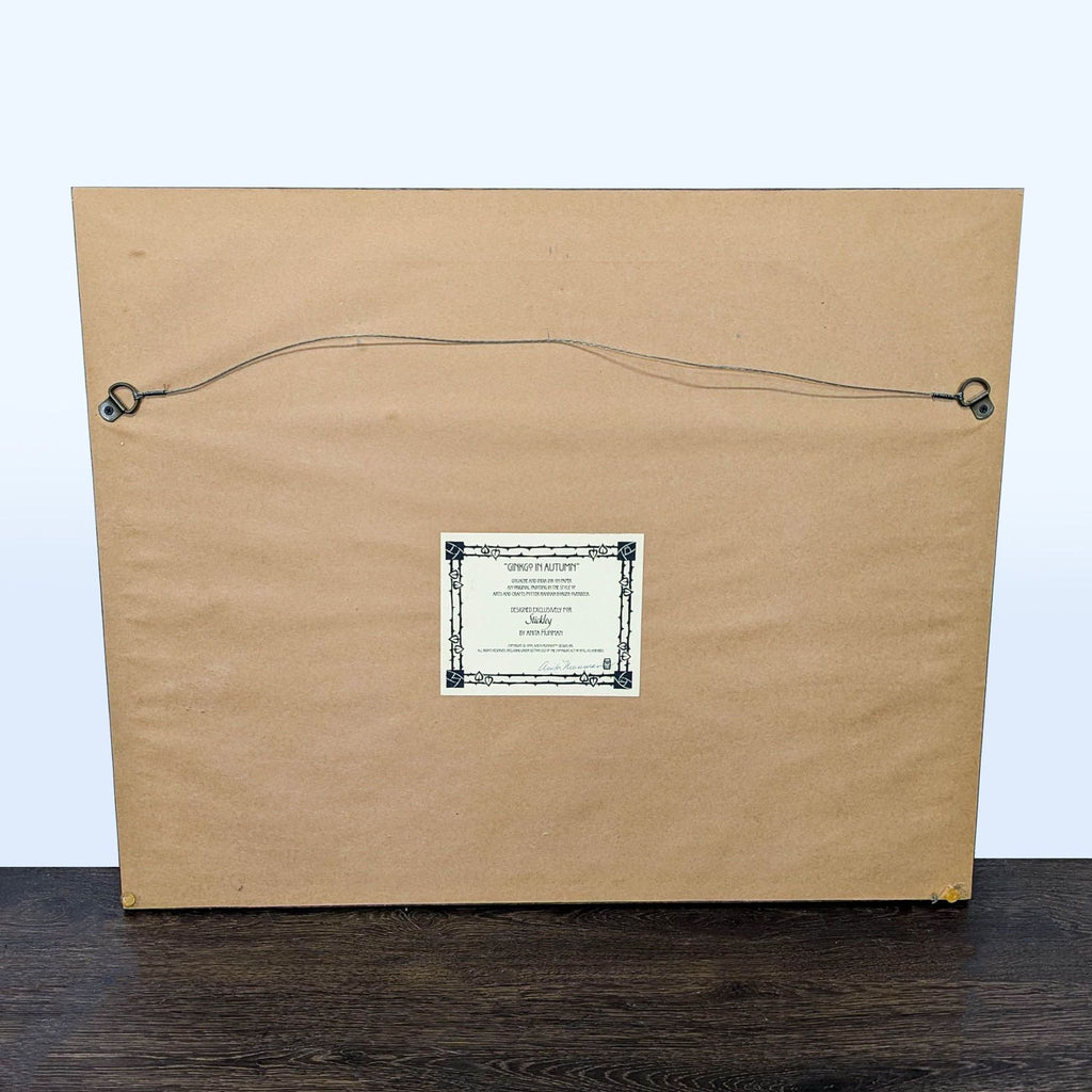 3. Back view of framed artwork showing hanging wire and attached certificate for “Ginkgo in Autumn” by Anita Munman.