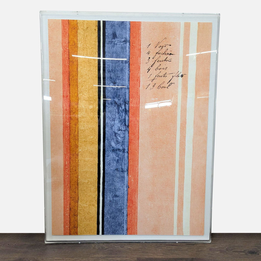 Abstract artwork of vertical bands in peach, gold, blue, and black, script details, in a clear acrylic shadowbox frame.  
