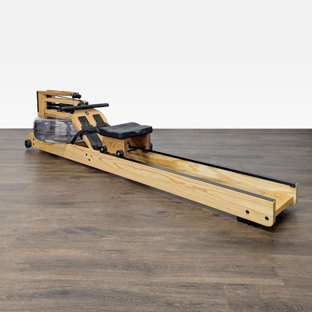 Solid ash WaterRower rowing machine with water tank, adjustable footrests, and cushioned seat for full-body exercise.
