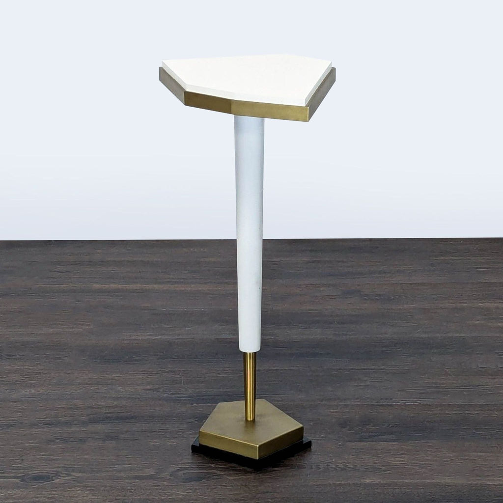 3. Stylish side table with an angular white surface, gold border, single tapered leg, and gold geometric base.
