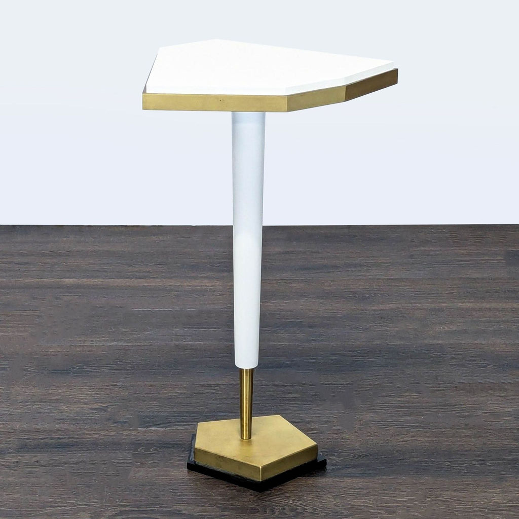 2. Contemporary console table featuring a geometric white top, gold trim, slender white leg, and sturdy gold base.